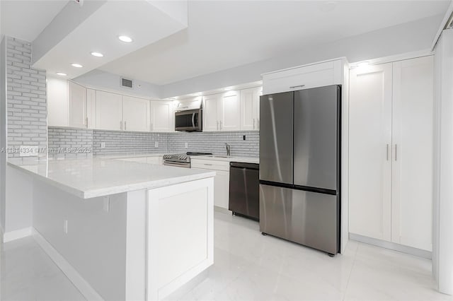 1201 S Ocean Dr Unit 610N, Hollywood, FL 33019 - kitchen with appliances with stainless steel finishes, a peninsula, white cabinetry, decorative backsplash, and recessed lighting