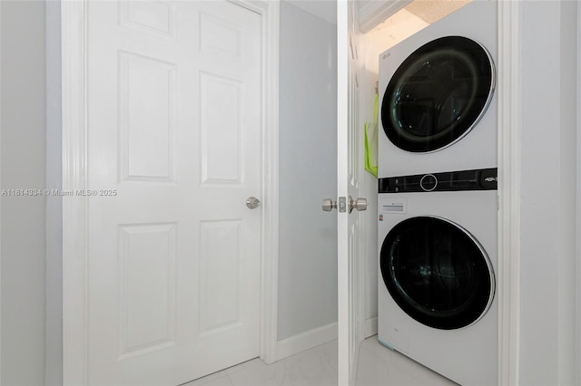 1201 S Ocean Dr Unit 610N, Hollywood, FL 33019 - laundry room with stacked washing machine and dryer, light marble finish flooring, and baseboards