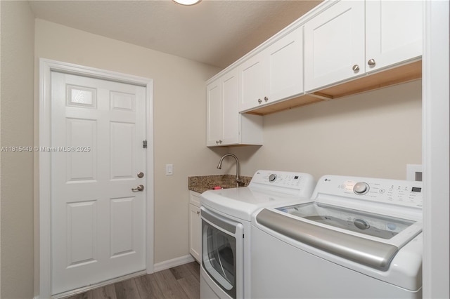 16365 SW 47th Ter, Ocala, FL 34473 - laundry area with washing machine and clothes dryer, cabinet space, wood finished floors, and baseboards