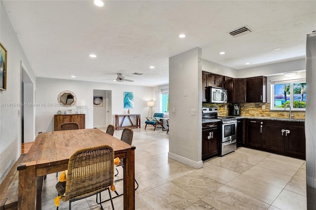 1083 SW 25th Pl, Boynton Beach, FL 33426 - kitchen with appliances with stainless steel finishes, tasteful backsplash, dark brown cabinetry, plenty of natural light, and recessed lighting