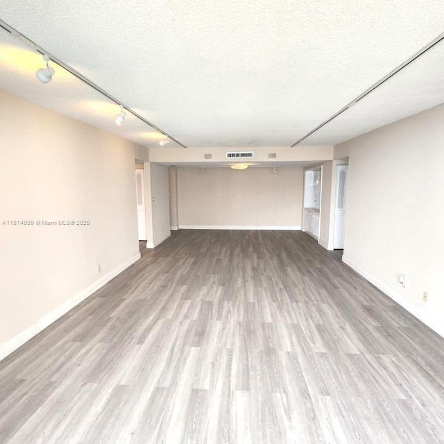 1801 S Flagler Dr Unit 1505, West Palm Beach, FL 33401 - empty room featuring wood finished floors, baseboards, rail lighting, and a textured ceiling