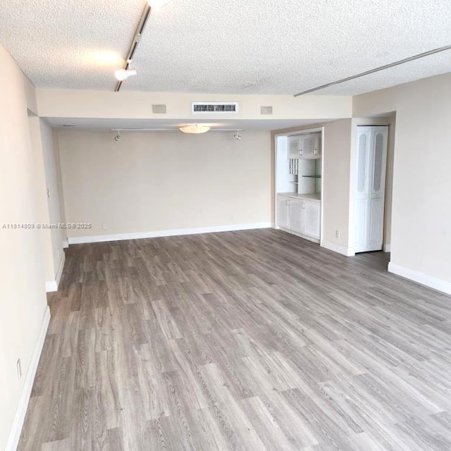 1801 S Flagler Dr Unit 1505, West Palm Beach, FL 33401 - empty room with wood finished floors, a textured ceiling, and baseboards