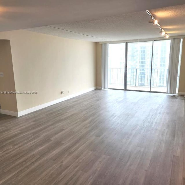 1801 S Flagler Dr Unit 1505, West Palm Beach, FL 33401 - empty room featuring baseboards, track lighting, dark wood finished floors, and a wall of windows