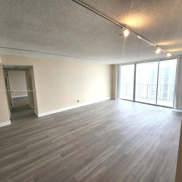 1801 S Flagler Dr Unit 1505, West Palm Beach, FL 33401 - unfurnished room featuring track lighting, a textured ceiling, dark wood-style floors, baseboards, and floor to ceiling windows