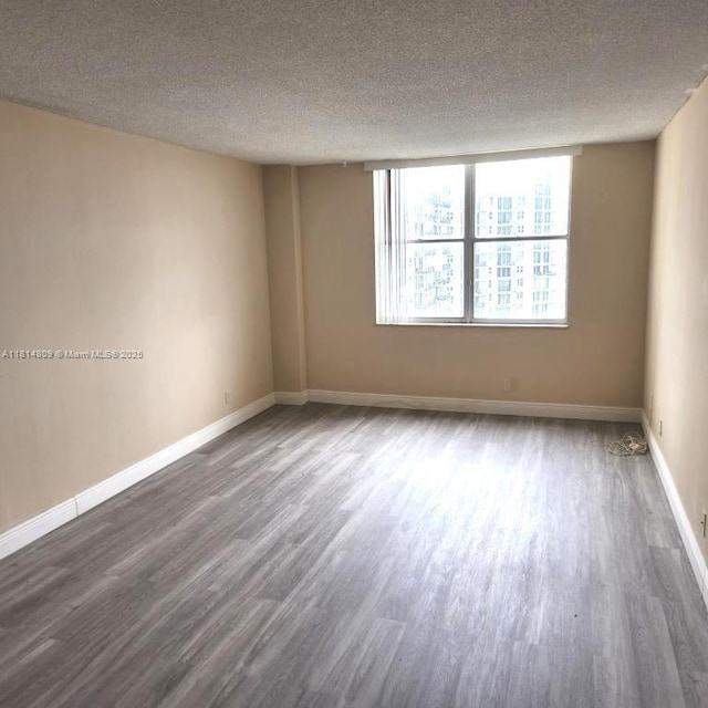 1801 S Flagler Dr Unit 1505, West Palm Beach, FL 33401 - spare room with wood finished floors, a textured ceiling, and baseboards