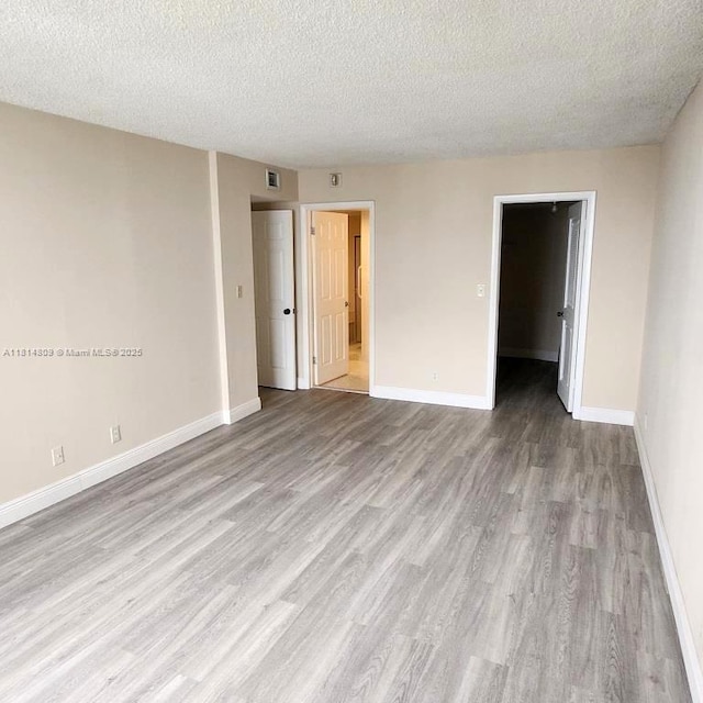 1801 S Flagler Dr Unit 1505, West Palm Beach, FL 33401 - unfurnished room with wood finished floors, a textured ceiling, and baseboards