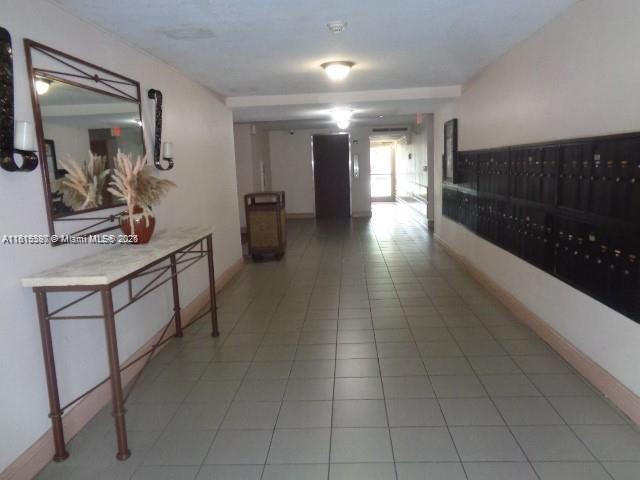 9320 Fontainebleau Blvd Unit 503, Miami, FL 33172 - hallway featuring mail area, light tile patterned floors, and baseboards