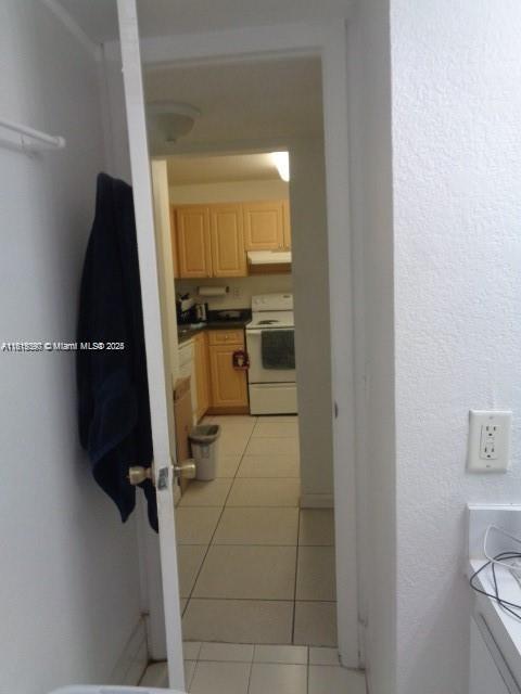 9320 Fontainebleau Blvd Unit 503, Miami, FL 33172 - kitchen featuring electric stove, under cabinet range hood, light brown cabinetry, and light tile patterned flooring