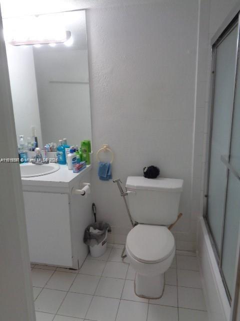 9320 Fontainebleau Blvd Unit 503, Miami, FL 33172 - full bath with toilet, vanity, tile patterned flooring, and combined bath / shower with glass door