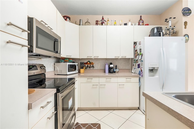 15683 NW 12th Rd, Pembroke Pines, FL 33028 - kitchen with stainless steel appliances, light countertops, tasteful backsplash, light tile patterned flooring, and white cabinetry
