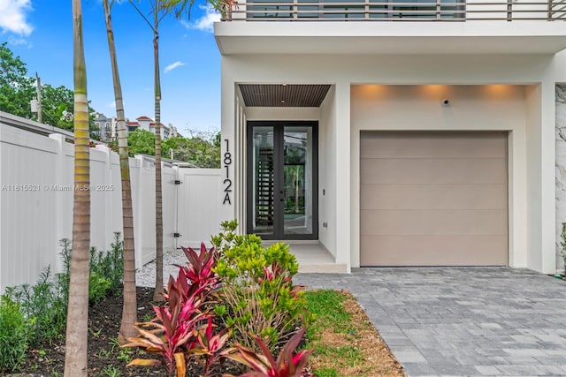 1812 Miami Rd, Fort Lauderdale, FL 33316 - doorway to property featuring french doors, a garage, stucco siding, a balcony, and driveway