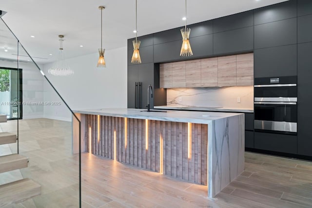 1812 Miami Rd, Fort Lauderdale, FL 33316 - kitchen with modern cabinets, stainless steel double oven, light countertops, an island with sink, and recessed lighting