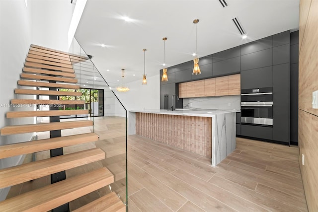 1812 Miami Rd, Fort Lauderdale, FL 33316 - kitchen featuring modern cabinets, stainless steel double oven, light countertops, and light wood-style floors