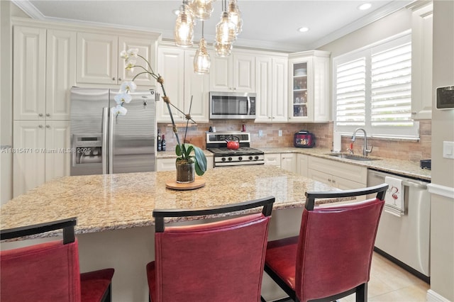 3063 NW 126th Ave, Sunrise, FL 33323 - kitchen featuring stainless steel appliances, ornamental molding, decorative backsplash, a kitchen island, and white cabinets