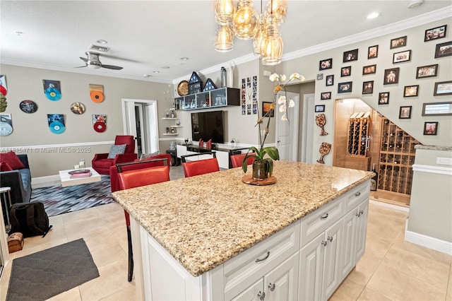 3063 NW 126th Ave, Sunrise, FL 33323 - kitchen with ornamental molding, light stone counters, a kitchen island, white cabinetry, and recessed lighting
