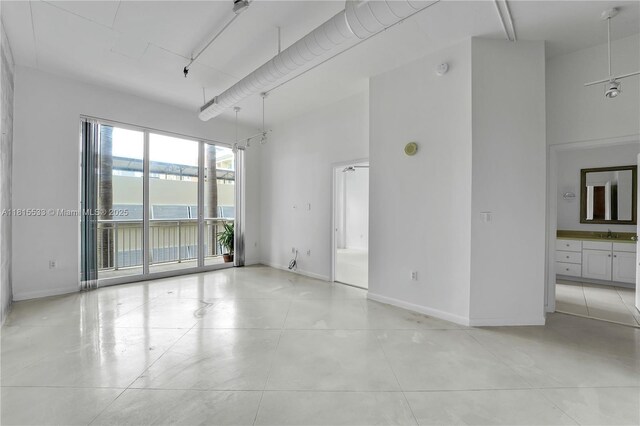 2001 Biscayne Blvd Unit 2305, Miami, FL 33137 - unfurnished room featuring a towering ceiling, a sink, baseboards, light tile patterned flooring, and a water view