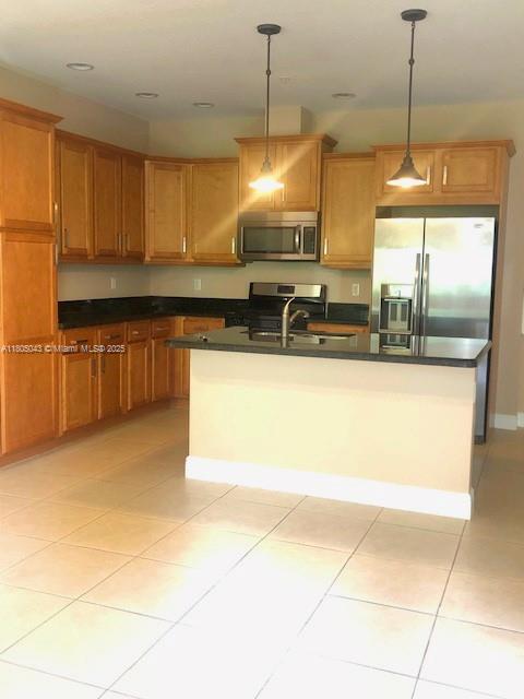 3311 NW 125th Ln, Sunrise, FL 33323 - kitchen with appliances with stainless steel finishes, dark countertops, hanging light fixtures, a sink, and an island with sink