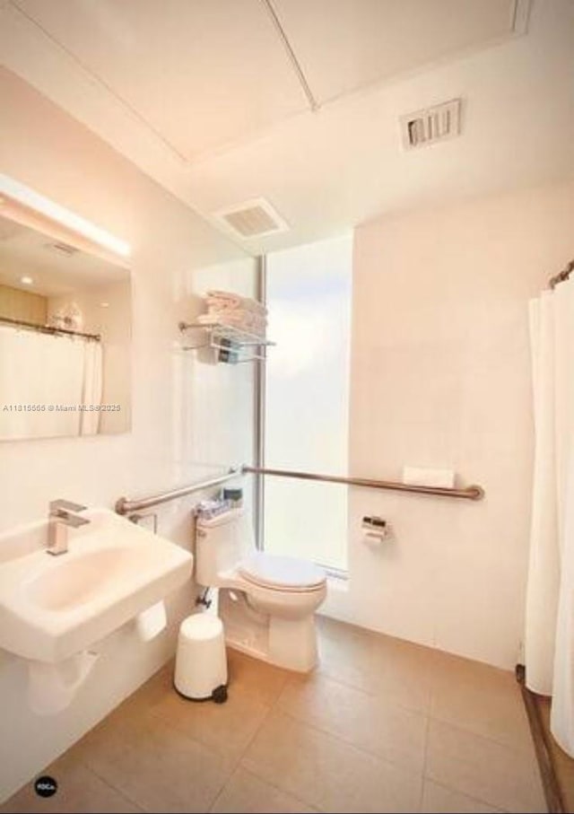 6080 Collins Ave Unit Ph09, Miami Beach, FL 33140 - bathroom featuring toilet, tile patterned flooring, a sink, and a shower with curtain