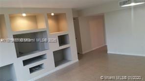 8045 SW 107th Ave Unit 323, Miami, FL 33173 - unfurnished living room featuring built in features and baseboards