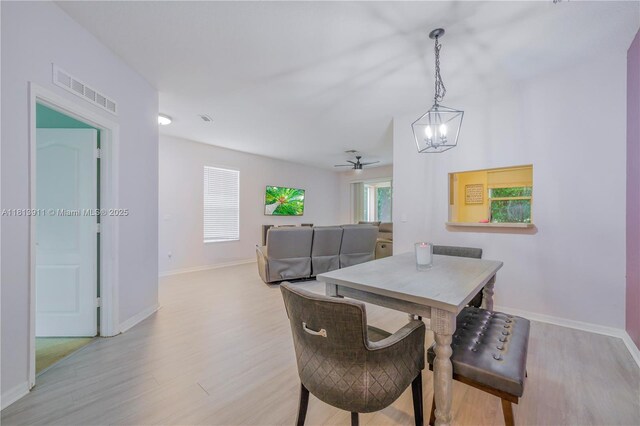 9722 SW Glenbrook Dr, Port St Lucie, FL 34987 - dining space featuring a chandelier, light wood-style floors, and baseboards