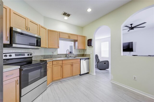 9722 SW Glenbrook Dr, Port St Lucie, FL 34987 - kitchen with stainless steel appliances, a sink, arched walkways, ceiling fan, and light countertops
