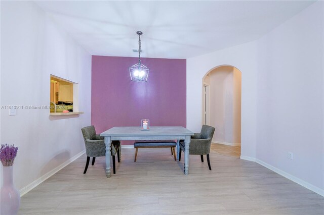 9722 SW Glenbrook Dr, Port St Lucie, FL 34987 - dining area featuring arched walkways, wood finished floors, and baseboards
