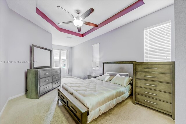9722 SW Glenbrook Dr, Port St Lucie, FL 34987 - bedroom featuring light colored carpet, a tray ceiling, baseboards, and a ceiling fan