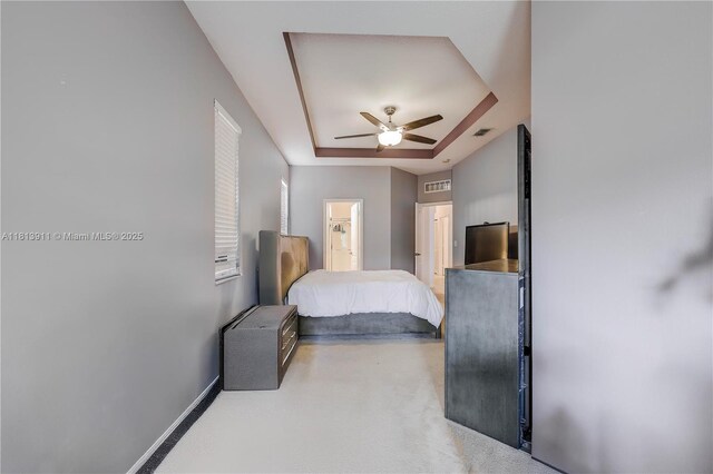 9722 SW Glenbrook Dr, Port St Lucie, FL 34987 - bedroom featuring a tray ceiling, baseboards, ensuite bathroom, and a ceiling fan