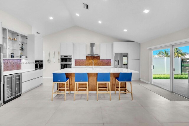 1240 NW 161st Ave, Pembroke Pines, FL 33028 - kitchen featuring wine cooler, wall chimney exhaust hood, modern cabinets, appliances with stainless steel finishes, and vaulted ceiling