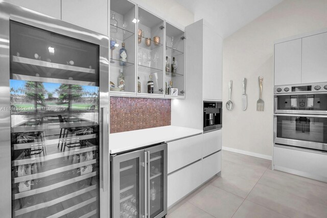 1240 NW 161st Ave, Pembroke Pines, FL 33028 - indoor dry bar with beverage cooler, stainless steel double oven, backsplash, and light tile patterned floors