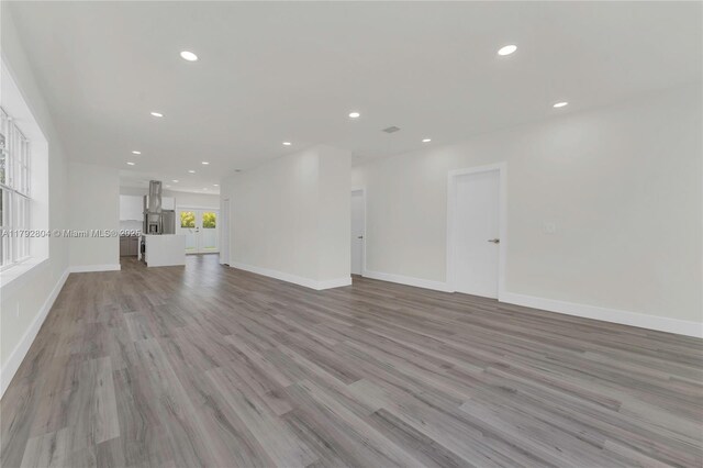 2357 SW 11th Ter, Miami, FL 33135 - unfurnished living room with light wood finished floors, baseboards, and recessed lighting