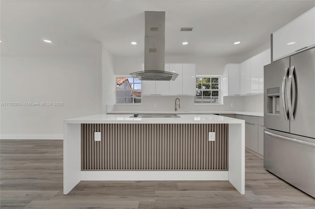 2357 SW 11th Ter, Miami, FL 33135 - kitchen with stainless steel refrigerator with ice dispenser, island range hood, modern cabinets, light countertops, and white cabinetry
