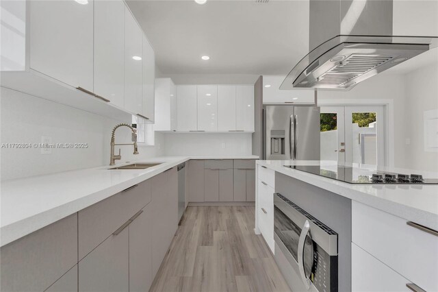 2357 SW 11th Ter, Miami, FL 33135 - kitchen featuring appliances with stainless steel finishes, a sink, modern cabinets, wall chimney exhaust hood, and light countertops