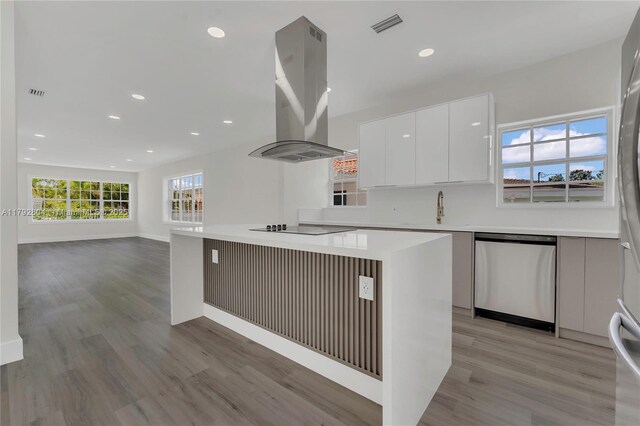 2357 SW 11th Ter, Miami, FL 33135 - kitchen with stainless steel dishwasher, island exhaust hood, modern cabinets, light wood-type flooring, and white cabinets