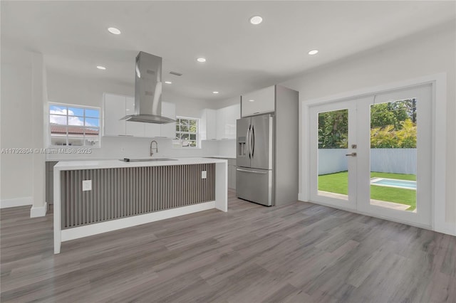 2357 SW 11th Ter, Miami, FL 33135 - kitchen featuring island range hood, stainless steel fridge, light countertops, modern cabinets, and white cabinets