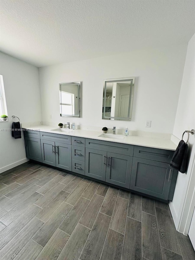 8036 104th Ct, Vero Beach, FL 32967 - bathroom featuring wood tiled floors, double vanity, and a textured ceiling