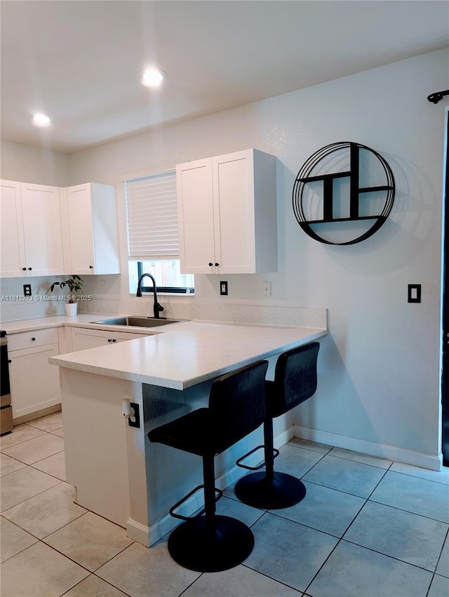 6489 N Anise Ct, Davie, FL 33314 - kitchen featuring a breakfast bar, white cabinets, a peninsula, light countertops, and recessed lighting
