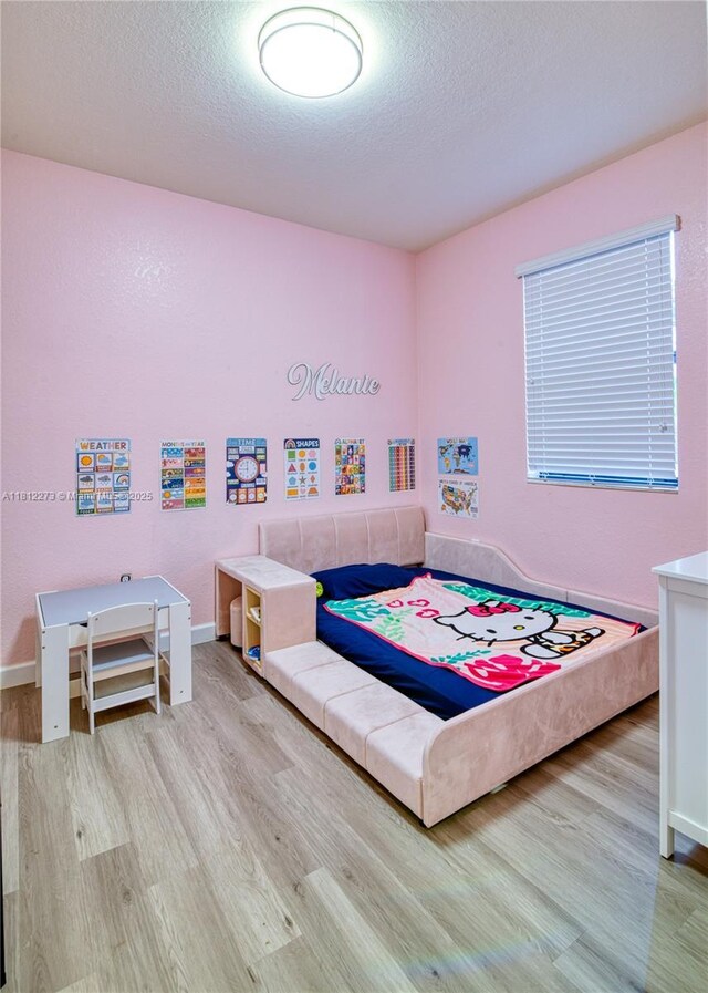 6489 N Anise Ct, Davie, FL 33314 - bedroom featuring wood finished floors, a textured ceiling, and baseboards