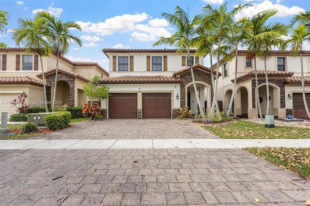 3401 SE 5th St, Homestead, FL 33033 - view of front of house with stone siding, decorative driveway, stucco siding, a garage, and a tiled roof