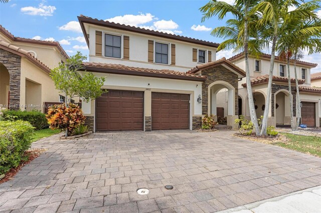 3401 SE 5th St, Homestead, FL 33033 - view of front of property featuring stone siding, stucco siding, a garage, decorative driveway, and a tile roof