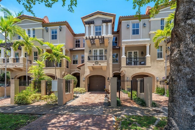 615 Santander Ave Unit C, Coral Gables, FL 33134 - mediterranean / spanish-style house featuring a garage, stucco siding, decorative driveway, and a balcony