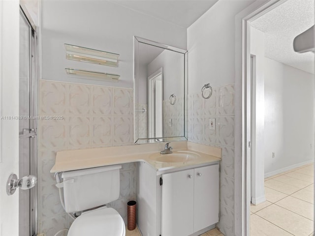 7905 W 30th Ct Unit 204, Hialeah, FL 33018 - bathroom featuring vanity, toilet, tile patterned floors, tile walls, and wainscoting