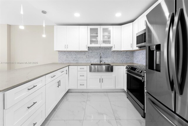 2851 NE 183rd St Unit 510E, Aventura, FL 33160 - kitchen featuring appliances with stainless steel finishes, a sink, a peninsula, light stone countertops, and white cabinetry