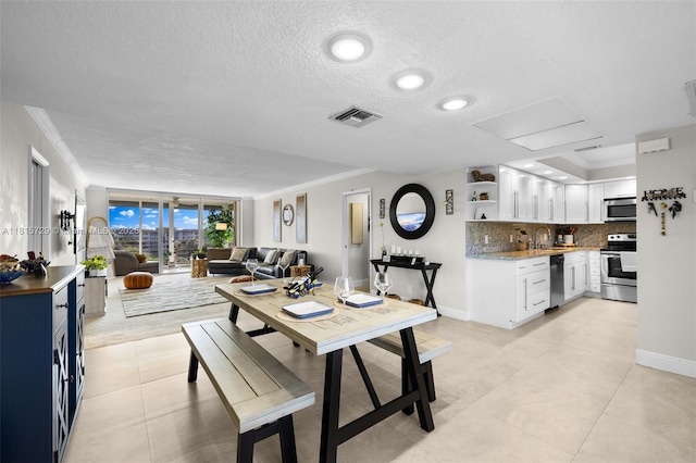 3850 E Oaks Clubhouse Dr Unit 504, Pompano Beach, FL 33069 - dining room with a textured ceiling, crown molding, baseboards, and light tile patterned flooring
