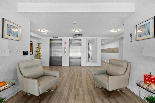 3850 E Oaks Clubhouse Dr Unit 504, Pompano Beach, FL 33069 - living area featuring elevator, wood finished floors, a textured wall, and a textured ceiling