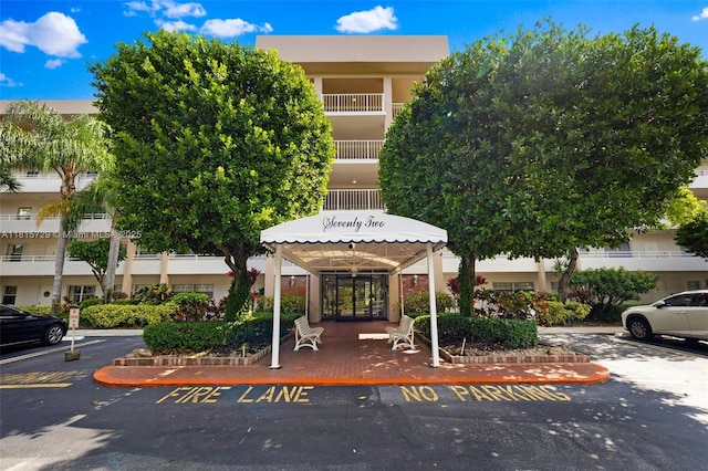 3850 E Oaks Clubhouse Dr Unit 504, Pompano Beach, FL 33069 - view of building exterior featuring uncovered parking