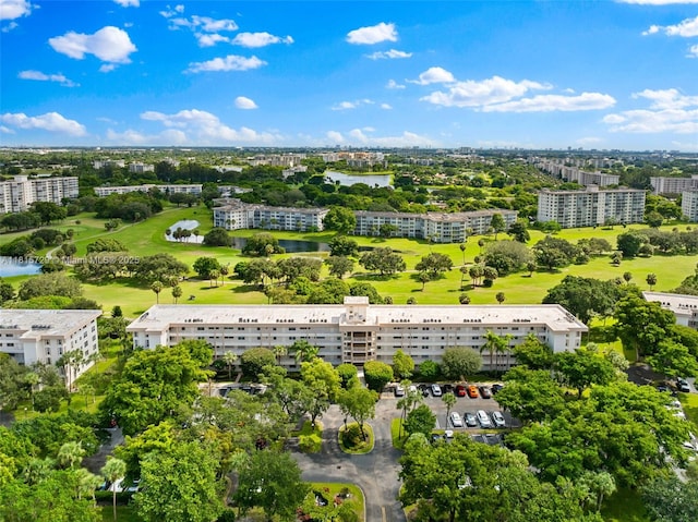 3850 E Oaks Clubhouse Dr Unit 504, Pompano Beach, FL 33069 - bird's eye view of apartment complex, a nearby body of water, a golf course, and a tree filled landscape