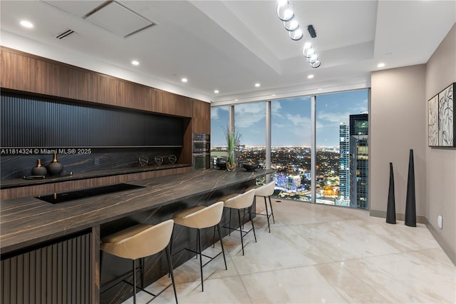1300 Brickell Bay Dr Unit 4400, Miami, FL 33131 - kitchen featuring expansive windows, recessed lighting, stainless steel double oven, a breakfast bar area, and a city view