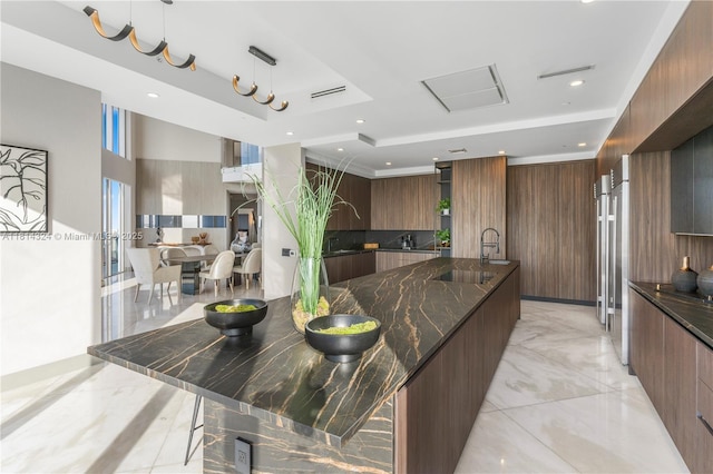 1300 Brickell Bay Dr Unit 4400, Miami, FL 33131 - kitchen featuring modern cabinets, a raised ceiling, a large island, light marble finish floors, and dark stone countertops