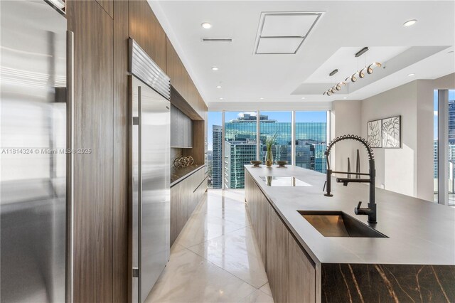 1300 Brickell Bay Dr Unit 4400, Miami, FL 33131 - kitchen with modern cabinets, a sink, a large island with sink, built in fridge, and recessed lighting